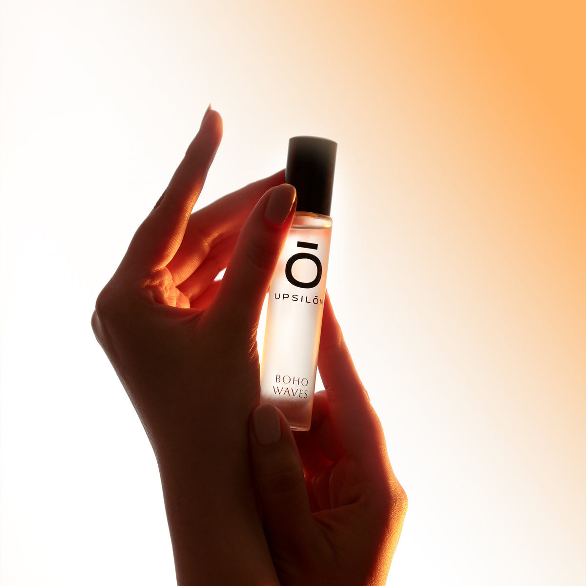 Applying UPSILON Eau de Parfum, a luxurious fragrance for women, with a focus on the delicate mist and the model's expression of enjoyment
